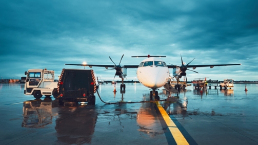 A busy airport in the rain. Preparation of the propeller airplane before flight.